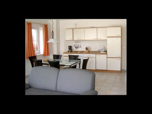 a living room and kitchen with a couch and a table at Ferienhof Peter in Vollerwiek