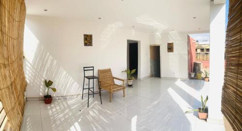 a white hallway with chairs and plants in a building at chambre confortable - aci 2000 hamdallaye bamako in Bamako