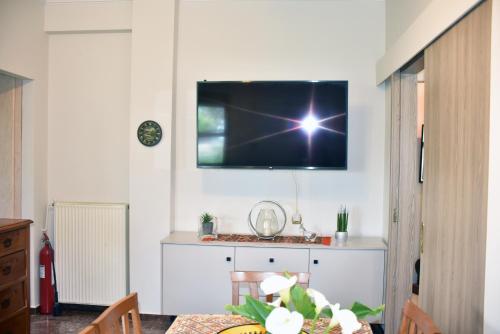 a living room with a television on a wall at Angelica's House in Pythagoreio