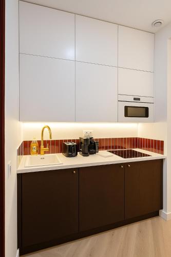 une cuisine avec des armoires blanches et un évier dans l'établissement Elegant Studio Paris X, Gare du Nord, à Paris