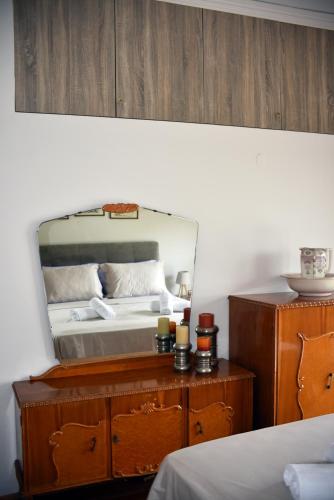 a bedroom with a bed and a mirror on a dresser at Angelica's House in Pythagoreio