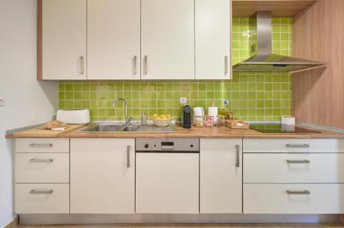 a kitchen with white cabinets and a sink at Peaceful Villa by Melides w Pool, by TimeCooler in Santiago do Cacém
