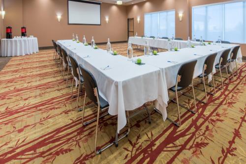a set of long tables in a room with a screen at Hotel 11, MOD A Sonesta Collection in Calgary