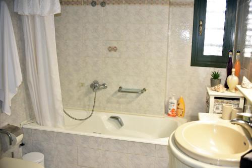 a bathroom with a bath tub and a sink at Angelica's House in Pythagoreio