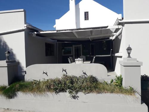 a white house with birds on the wall at Bell Guesthouse in Somerset East