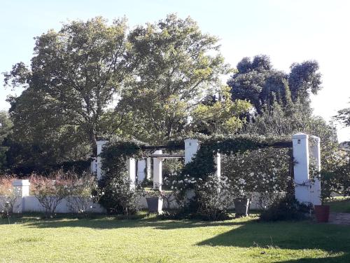 a garden with a white fence and a tree at Bell Guesthouse in Somerset East