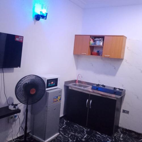 a small kitchen with a sink and a fan at Peace Home in Lekki