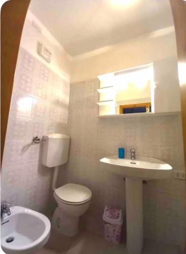 a bathroom with a white toilet and a sink at Sweet home A&C in Conversano