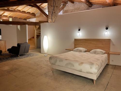 une chambre avec un grand lit et une chaise dans l'établissement Exceptional building on 1 ha of private land, à Marsillargues
