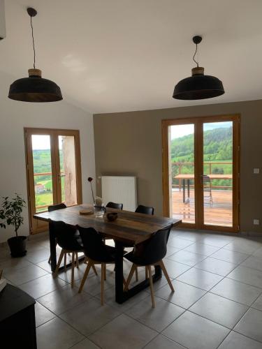 une salle à manger avec une table et des chaises en bois dans l'établissement Detached stone house with terrace in Ardèche, à Alboussière