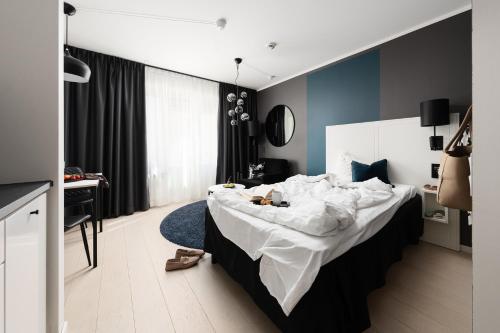 a bedroom with a large bed and a desk at Sky Hotel City Apartments in Linköping
