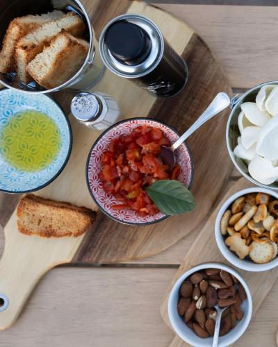a table with bowls of food on a wooden cutting board at Ciriga Sicily Glamping in Santa Maria Del Focallo