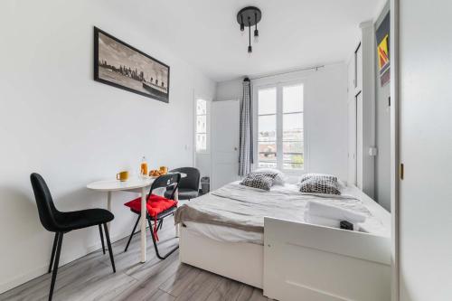 une chambre avec un lit, une table et des chaises dans l'établissement Studio Cosy proche tour Eiffel - Paris 7 - 2P, à Paris