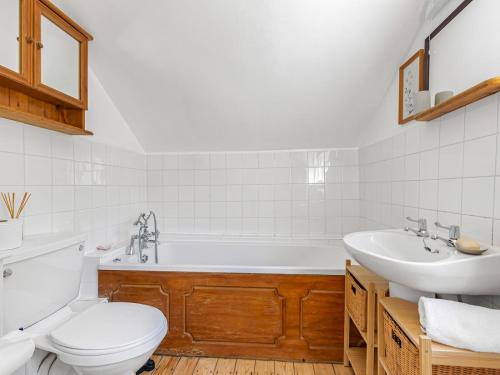 a bathroom with a tub and a toilet and a sink at Pass the Keys Cosy Garden Home in Canterbury