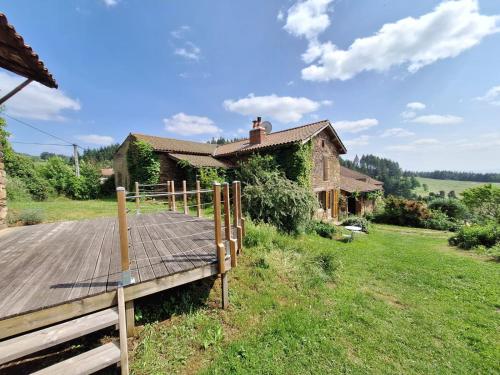 un ponte di legno di fronte a una casa di Eco-gîte panoramique face aux volcans avec ateliers couture bohème en option a Champagnac-le-Vieux