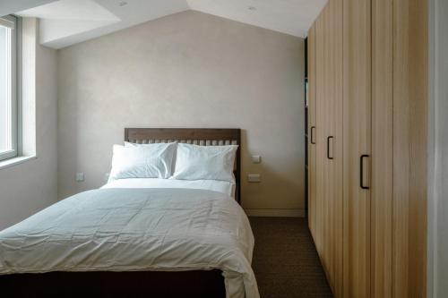 a bedroom with a large bed with white sheets at Modern Chatham home with garden retreat in Chatham