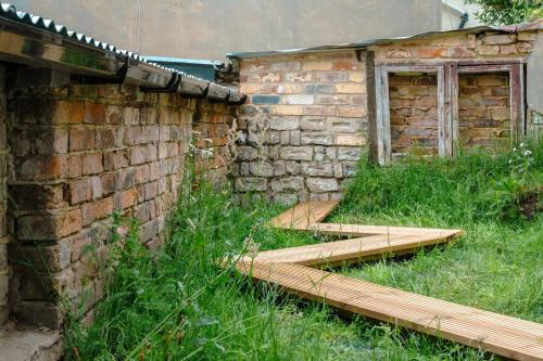 an old building with wooden steps next to a brick wall at Modern Chatham home with garden retreat in Chatham