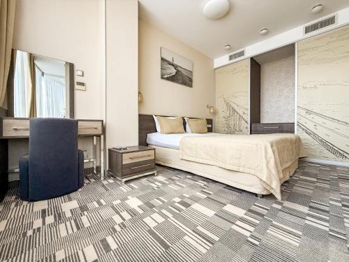 a bedroom with a bed and a desk and a chair at 12th Floor Apartments in Odesa