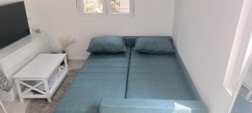 ストモレにあるWhite apartmentの隅に大きな緑のベッドがある小さな部屋