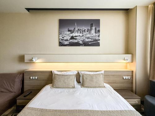 a bedroom with a bed and a picture of a city at 12th Floor Apartments in Odesa