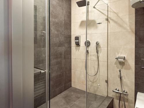 a shower with a glass door in a bathroom at 12th Floor Apartments in Odesa