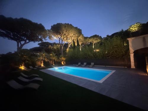 une piscine dans un jardin la nuit dans l'établissement VILLA Azzurra, à Sainte-Maxime