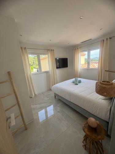 a bedroom with a large bed and two windows at VILLA Azzurra in Sainte-Maxime