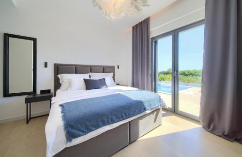 Ένα ή περισσότερα κρεβάτια σε δωμάτιο στο Luxury Villa Harmony with heated pool and seaview