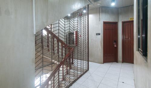 a staircase in a hallway with a red door at Rcee Place by RedDoorz in Cebu City