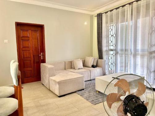a living room with a couch and a fan at 2Bedroom flat, free Wi-Fi near acacia mall in Nalakonge