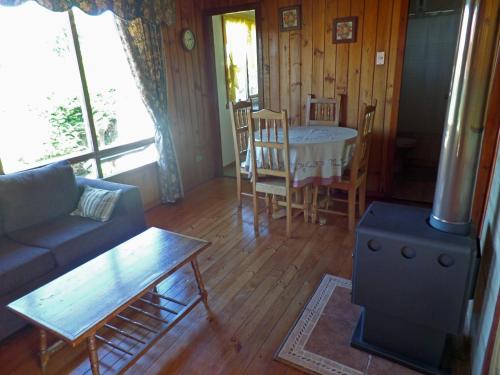a living room with a couch and a table and chairs at Hostal y Cabañas Villa Germana in Puerto Varas