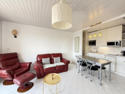 - un salon doté d'un mobilier rouge et d'une table dans l'établissement Sol-y-Days Soleil du Couchant Appartement avec terrasse et parking, à La Grande Motte