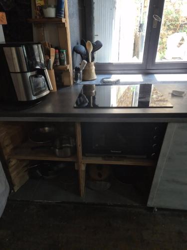 a desk with a counter top with a window at La Dorette - Dans le parc naturel LIvradois-Forez in Arlanc