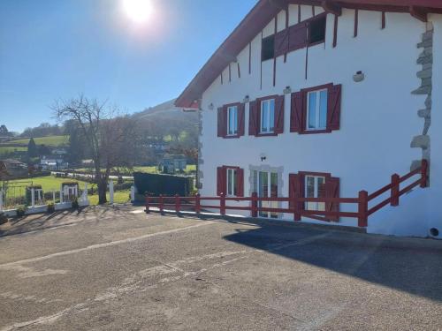 a white building with a red fence around it at Kazerna in Hélette