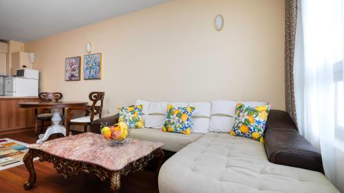 a living room with a white couch and a table at Превъзходен апартамент Къщата на Мечтите-Златни пясъци на първа линия in Varna City