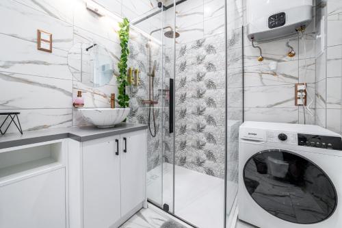 a white bathroom with a washing machine in a shower at Dani Lux by Mital in Szeged
