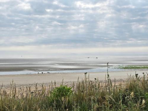 a beach with a group of people on the sand at Relais des îles Saint Marcouf in Saint-Marcouf
