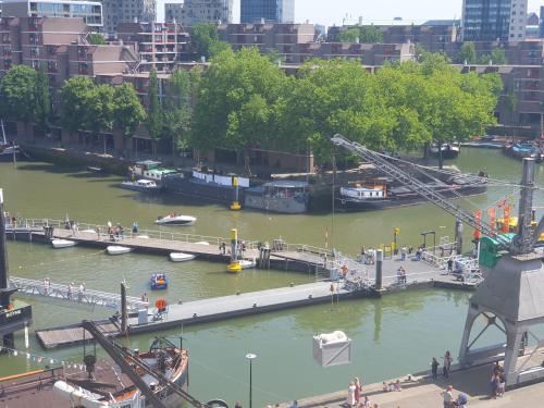 a view of a river with boats and a crane at Houseboat holiday apartments Rotterdam in Rotterdam