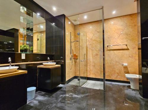 a bathroom with a shower and two sinks and a toilet at St Mary Kuala Lumpur Homestay Bathtub & Walk to Pavilion Bukit Bintang by Cloud Host in Kuala Lumpur