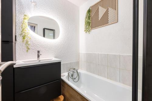 une salle de bain avec un lavabo, une baignoire et un miroir dans l'établissement Agréable 28m² - Ski aux pieds, au Corbier