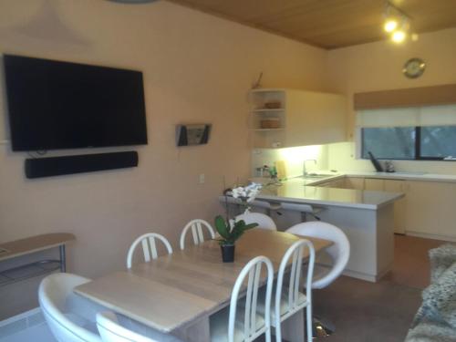 a kitchen with a table and chairs and a television at KILIMANJARO ALPINE APARTMENTS 3 BEDROOM Apartment in Falls Creek