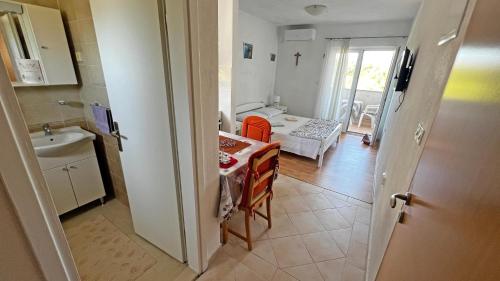 una cucina con tavolo e lavandino e una camera di Apartmani Veronika a Rudina