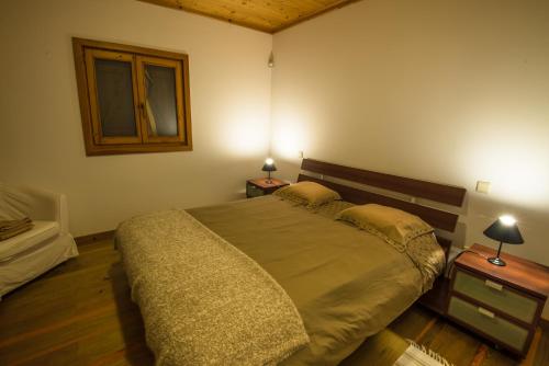 a bedroom with a large bed and two tables with lamps at Quinta dos Curubas in Vila Franca do Campo