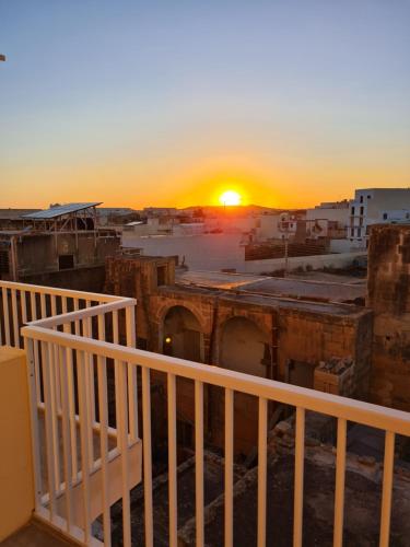 a view of the sunset from a balcony of a city at Richard's Living in Xewkija