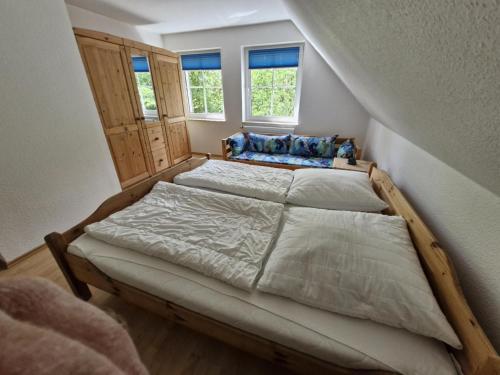 a bedroom with two beds and two windows at Ferienhof Peter in Vollerwiek