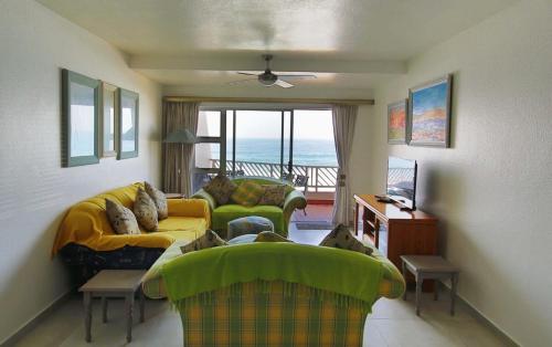 a living room with two couches and a view of the ocean at 24 Isikhulu Umdloti Beachfront in Umdloti
