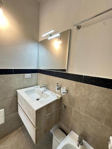 a bathroom with a sink and a toilet and a mirror at Agricampeggio Tenuta Ferrario in Baia Verde