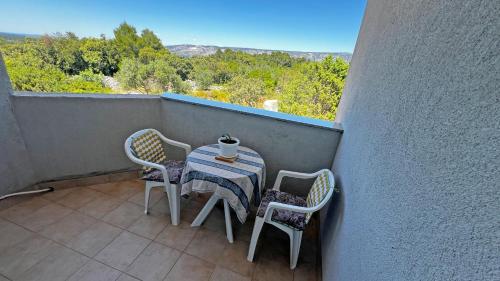 un piccolo tavolo con sedie su un balcone con vista di Apartmani Veronika a Rudina