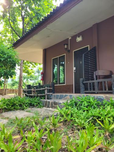 a front porch of a house with plants at Baan Varintorn Suanphueng in Suan Phung