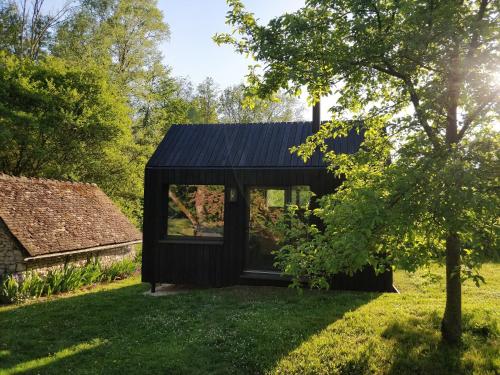 una casa negra con techo negro en La Tiny House de La Rivière, en Sceaux-du-Gâtinais